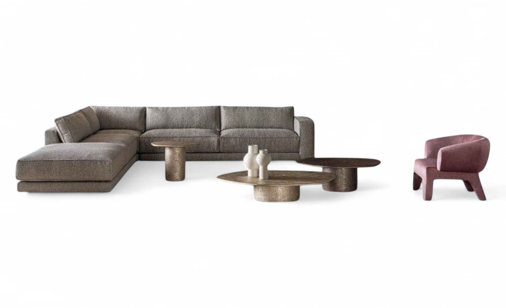 View of gray sectional sofa, three metal tables, pink armchair, vases.