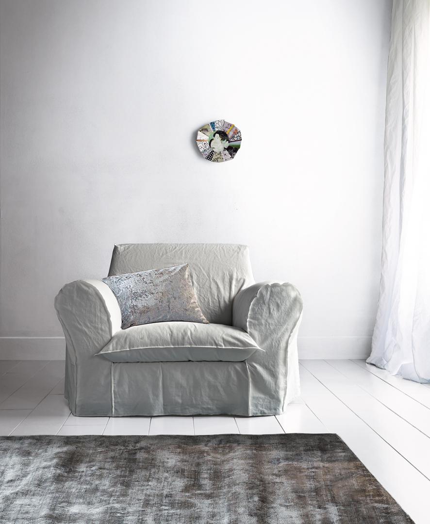 Interior with Casamilano Big XL armchair, decorative pillow, rug, and art creating a cozy living room ambiance