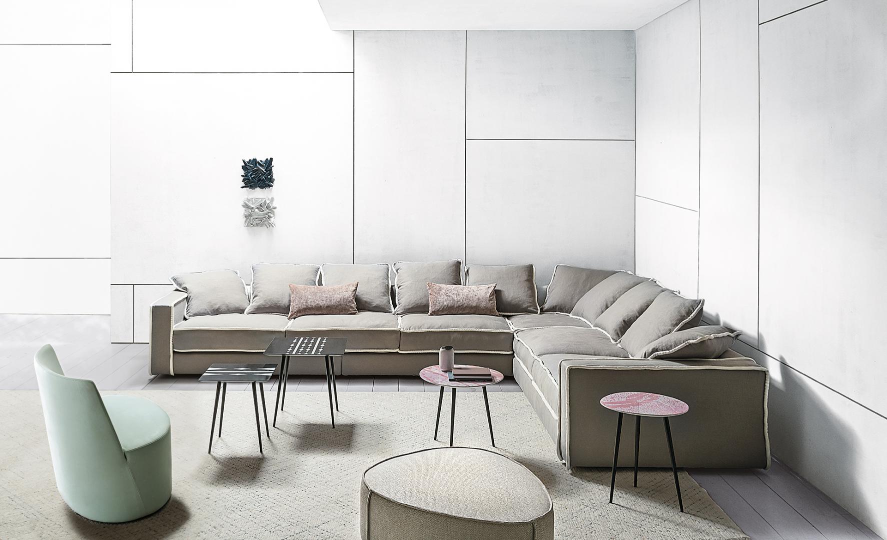 Modern living room featuring a modular sofa, mint green Lea accent chair by Casamilano, and sleek coffee tables