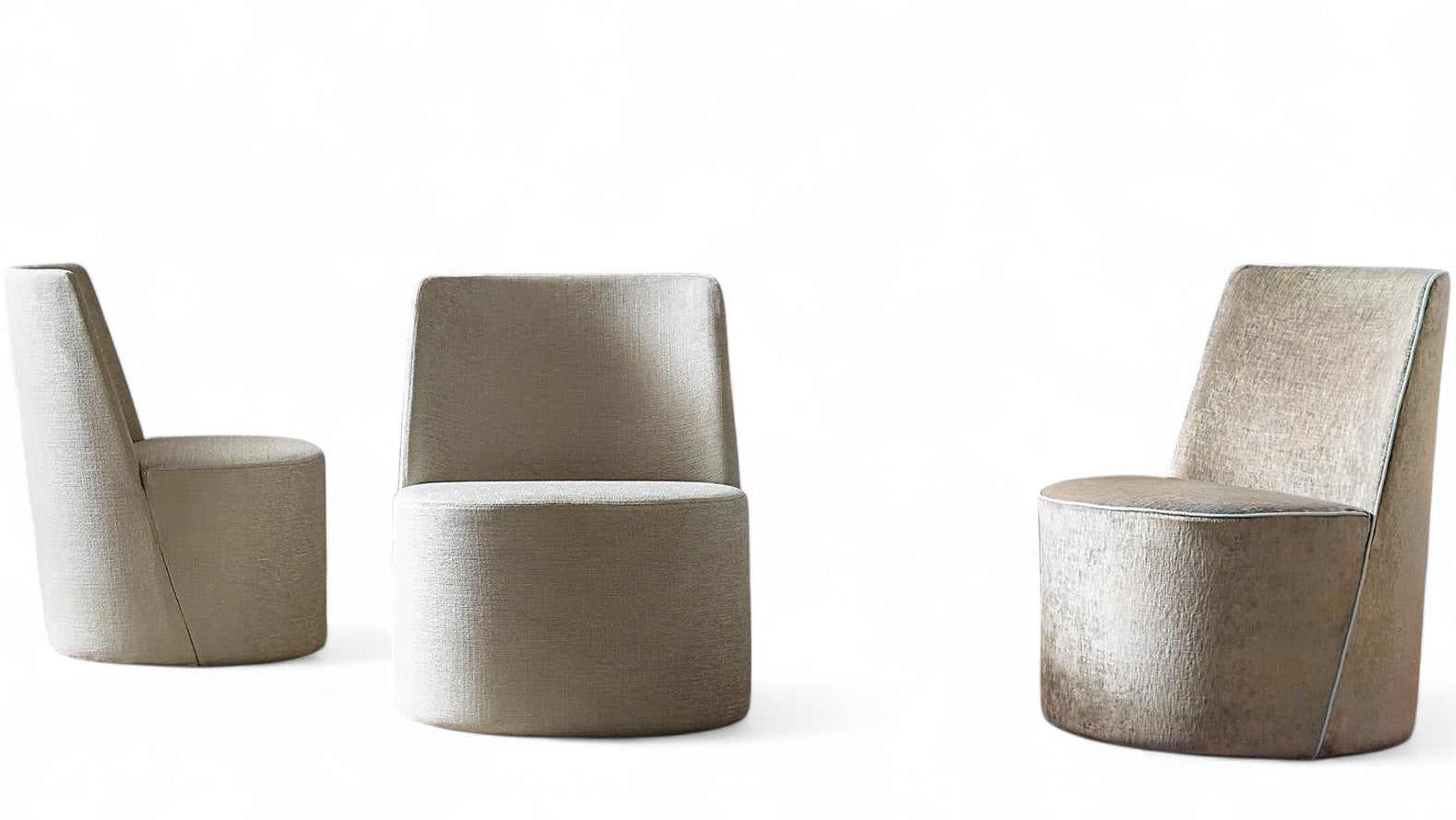 Studio shot of three upholstered armless chairs on white background.