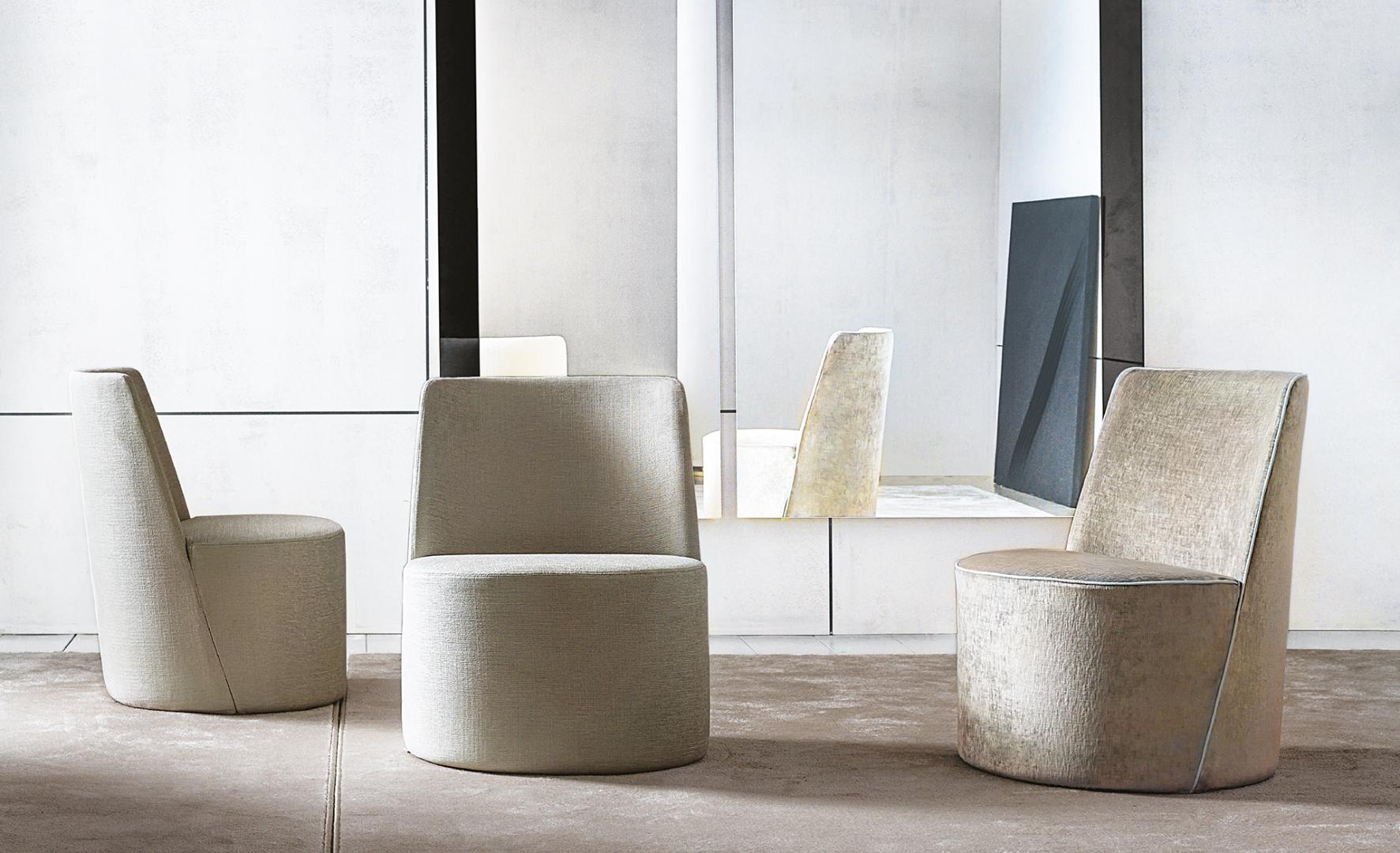 Interior with three Casamilano Lea chairs featuring cylindrical bases and high backrests, upholstered in elegant fabric, minimalist design