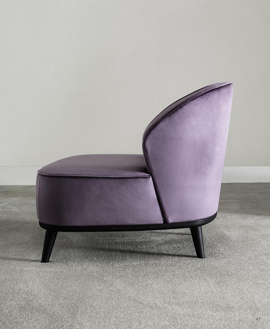 Side view of the Dhora accent chair by Casamilano, featuring plush purple velvet upholstery and sleek black legs