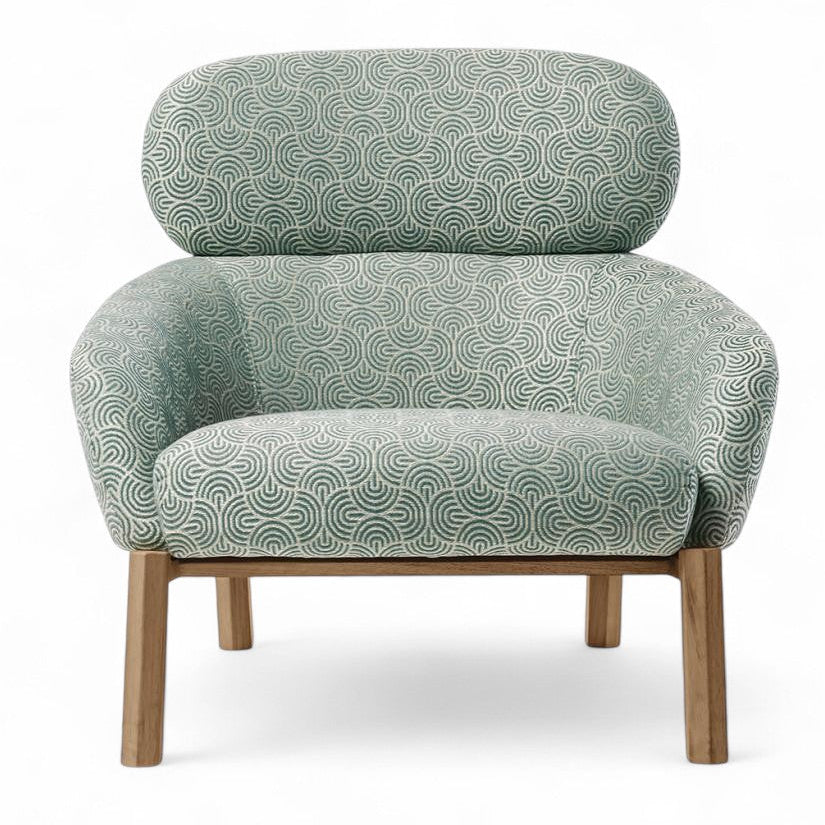 Studio shot of upholstered armchair with green geometric pattern and wood legs, accent chair, living room furniture, modern seating