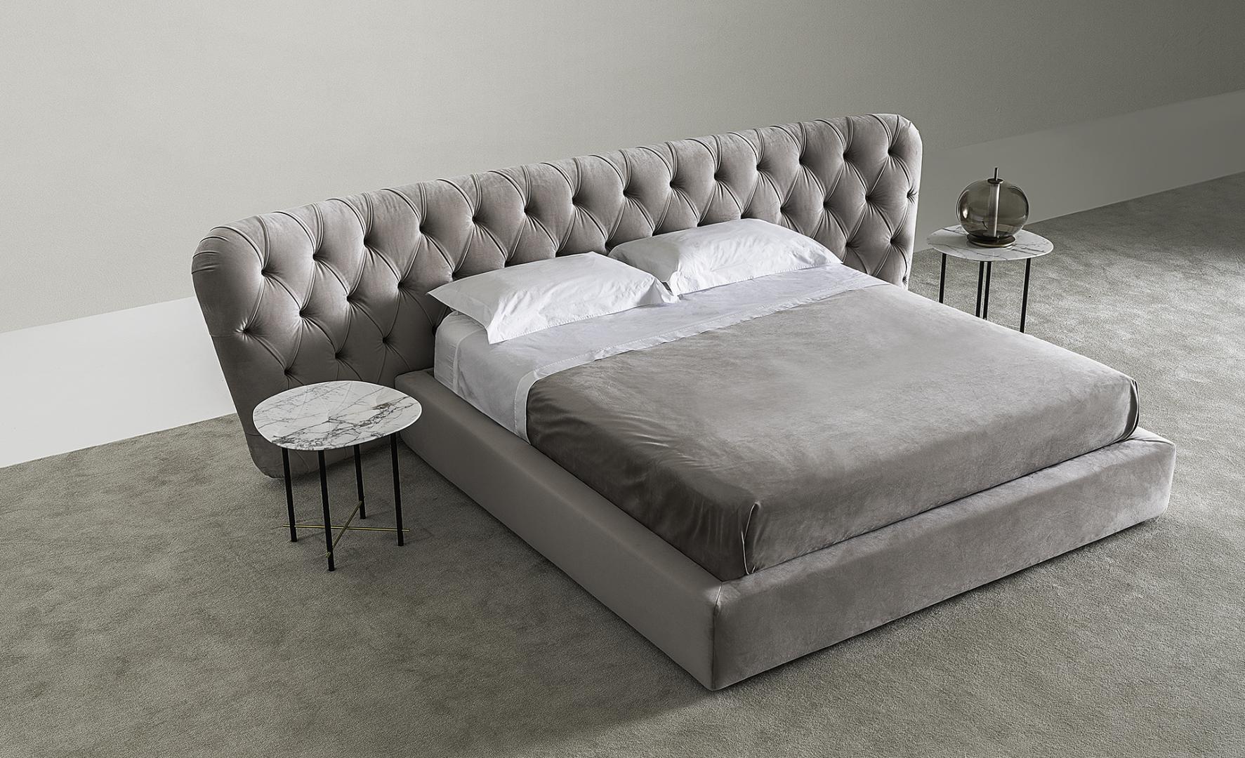 Luxurious bedroom interior showcasing the modern Casamilano Royale Capitonné bed with tufted headboard and marble side tables