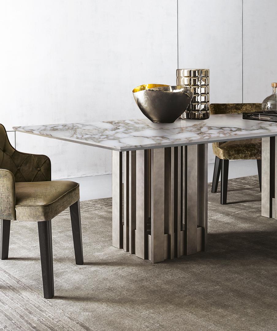 Interior of a dining room with a marble-topped Casamilano Empire dining table and upholstered chairs, showcasing modern luxury