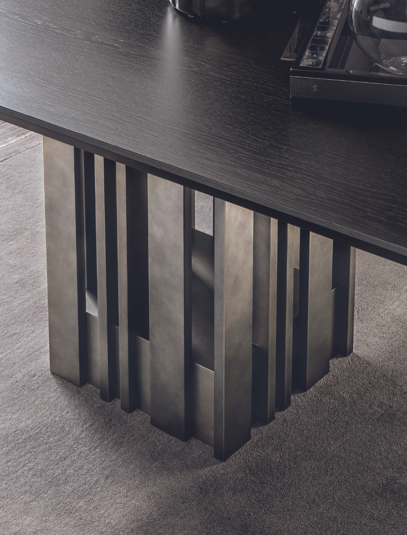 Close-up of the Casamilano Empire dining table featuring a dark wood top and unique sculptural metal base. Modern luxury for contemporary dining.