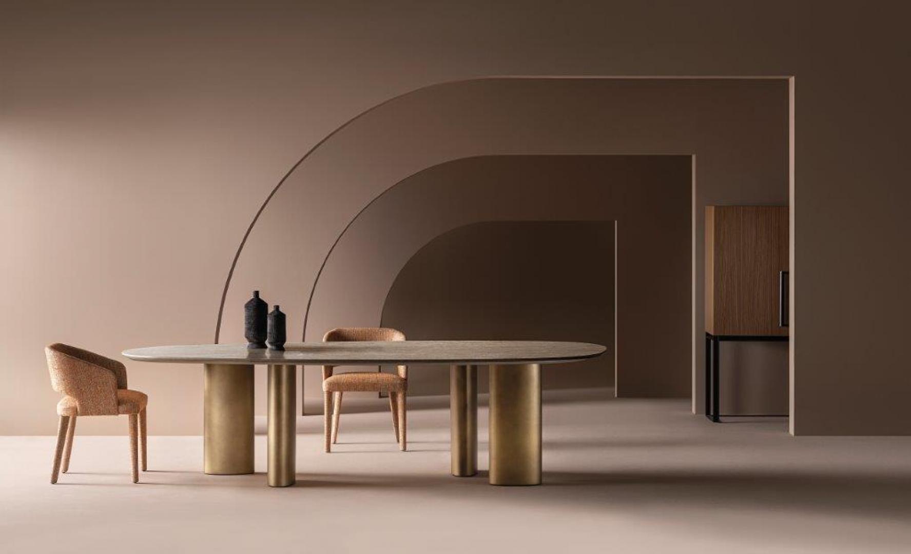 Modern dining room featuring the Casamilano Arne dining table with oval top and metallic base, surrounded by upholstered chairs