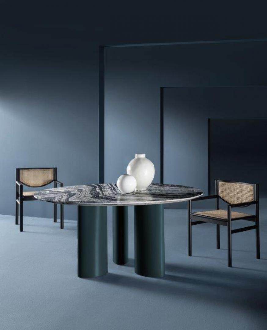 Modern dining room featuring the Casamilano Arne dining table with marble top, cane back chairs, and stylish decor in a blue interior