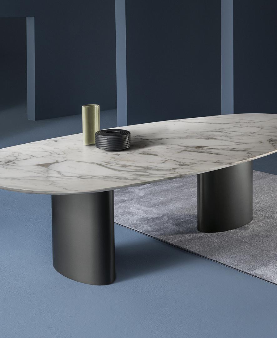 Interior of a modern dining room featuring a Casamilano Tangeri 280 x 135 oval table with a marble top and dark gray cylindrical legs