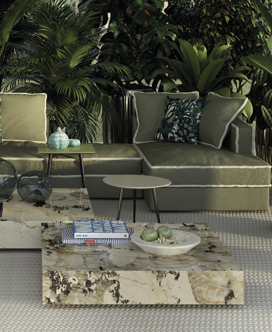 Outdoor living space featuring a Casamilano Ishi marble coffee table, modular sofa, and tropical foliage, perfect for luxury outdoor living