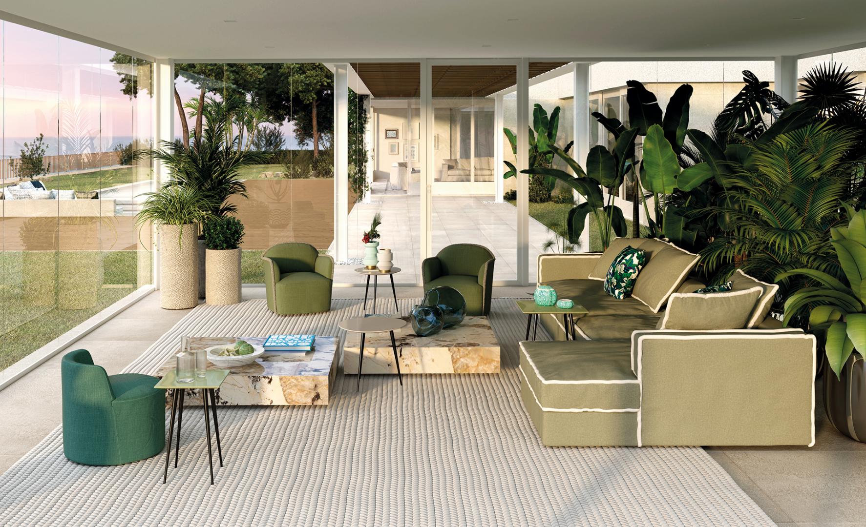 Modern living room featuring a green modular sofa, armchairs, stone Ishi coffee tables by Casamilano, and ocean views.