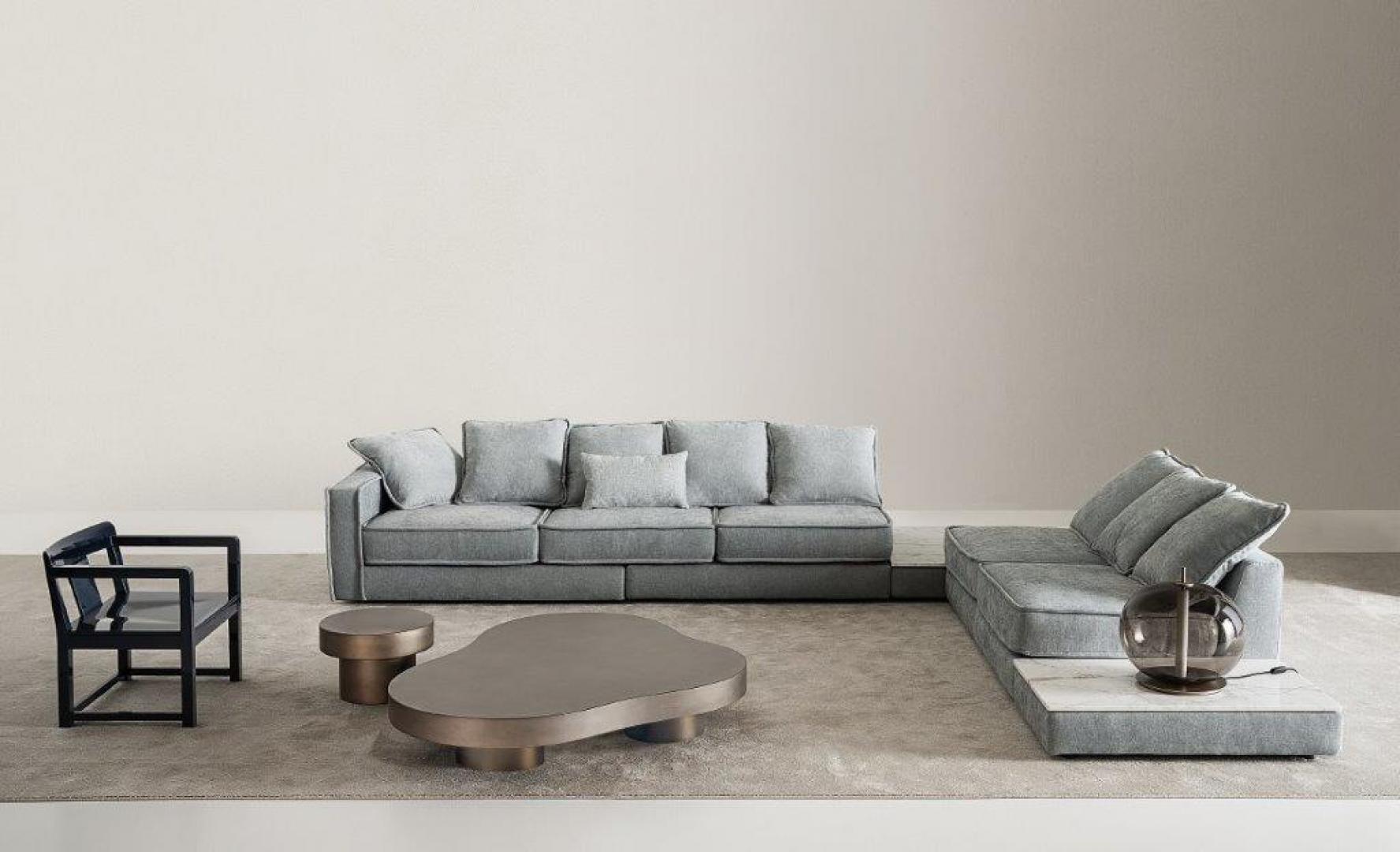 Interior of a modern living room featuring a Casamilano Nuvola coffee table, sectional sofa, and minimalist chair, showcasing contemporary design