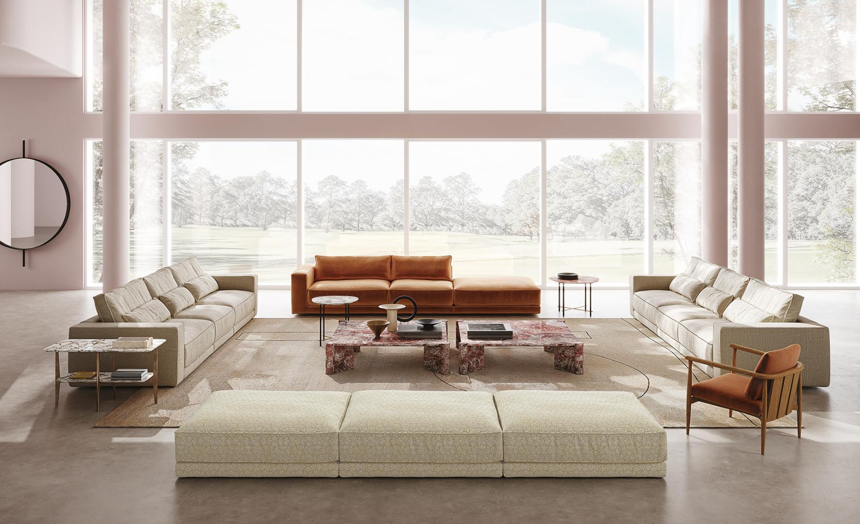 Modern living room featuring Casamilano Petra coffee tables, neutral sofas, orange armchair, patterned ottoman, and ample natural light.