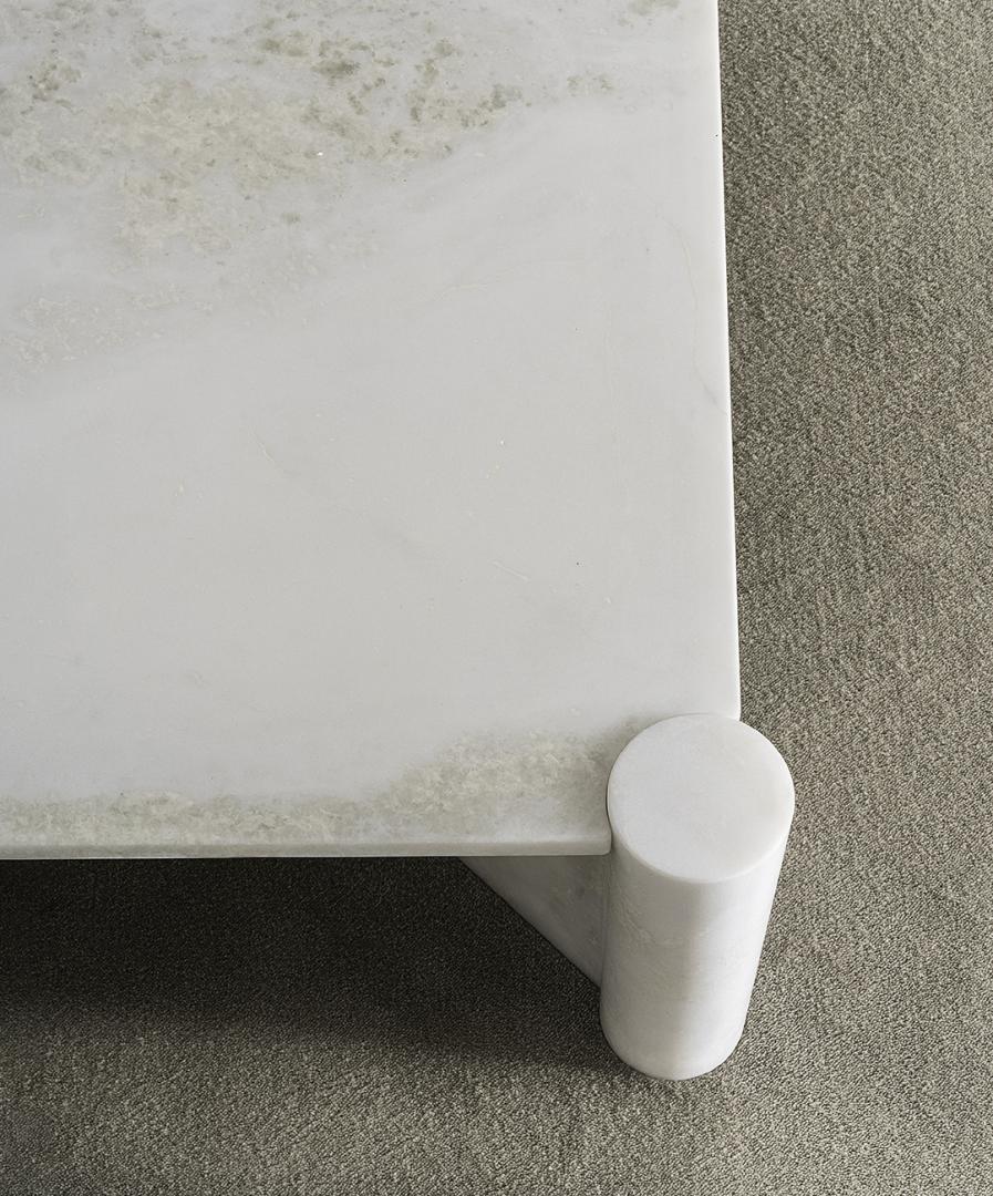 Close-up of Casamilano Petra marble coffee table featuring a square top and cylindrical leg; modern, luxury living room furniture
