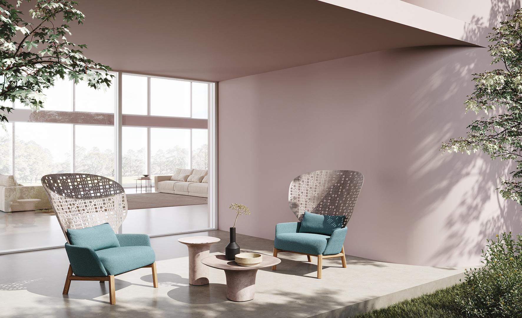Casamilano Callas IN & OUTDOOR woven armchairs with blue cushions and stone accent table create a luxurious outdoor living space