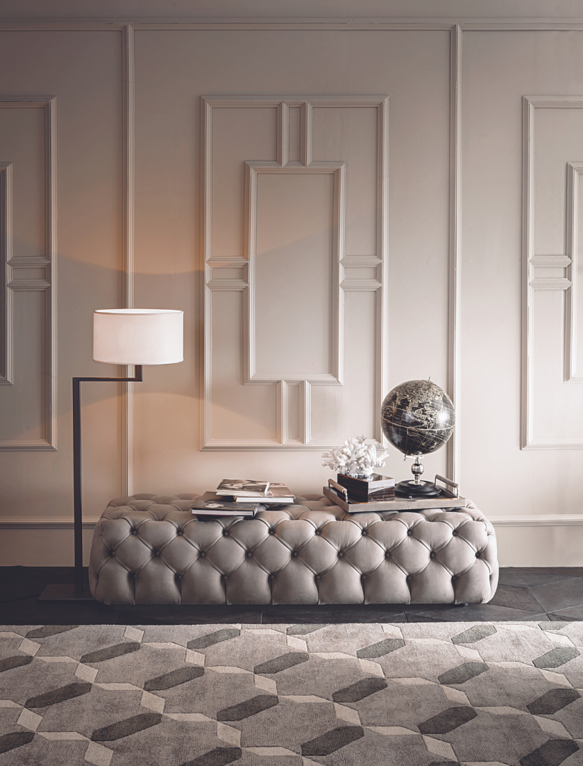 Living space featuring a Casamilano Hyatt 160 tufted ottoman, modern floor lamp, and patterned rug for a contemporary living room design