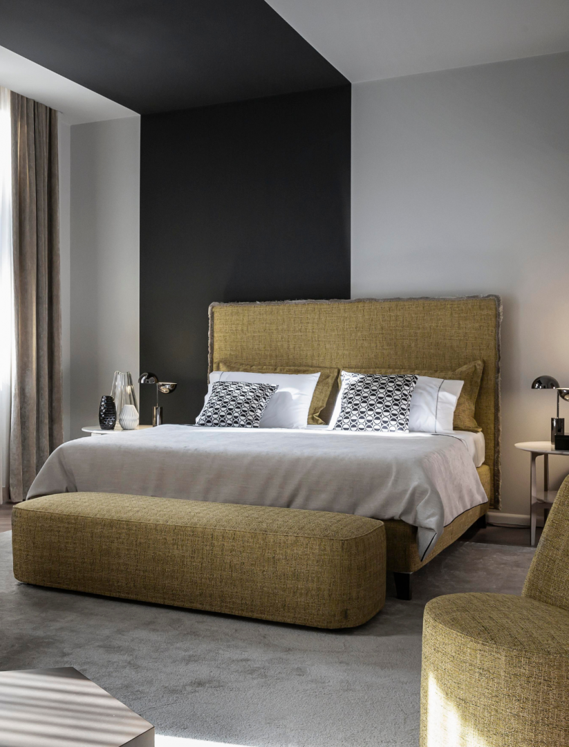 Modern bedroom featuring a Casamilano upholstered bed with textured headboard and matching bench, showcasing luxury home decor