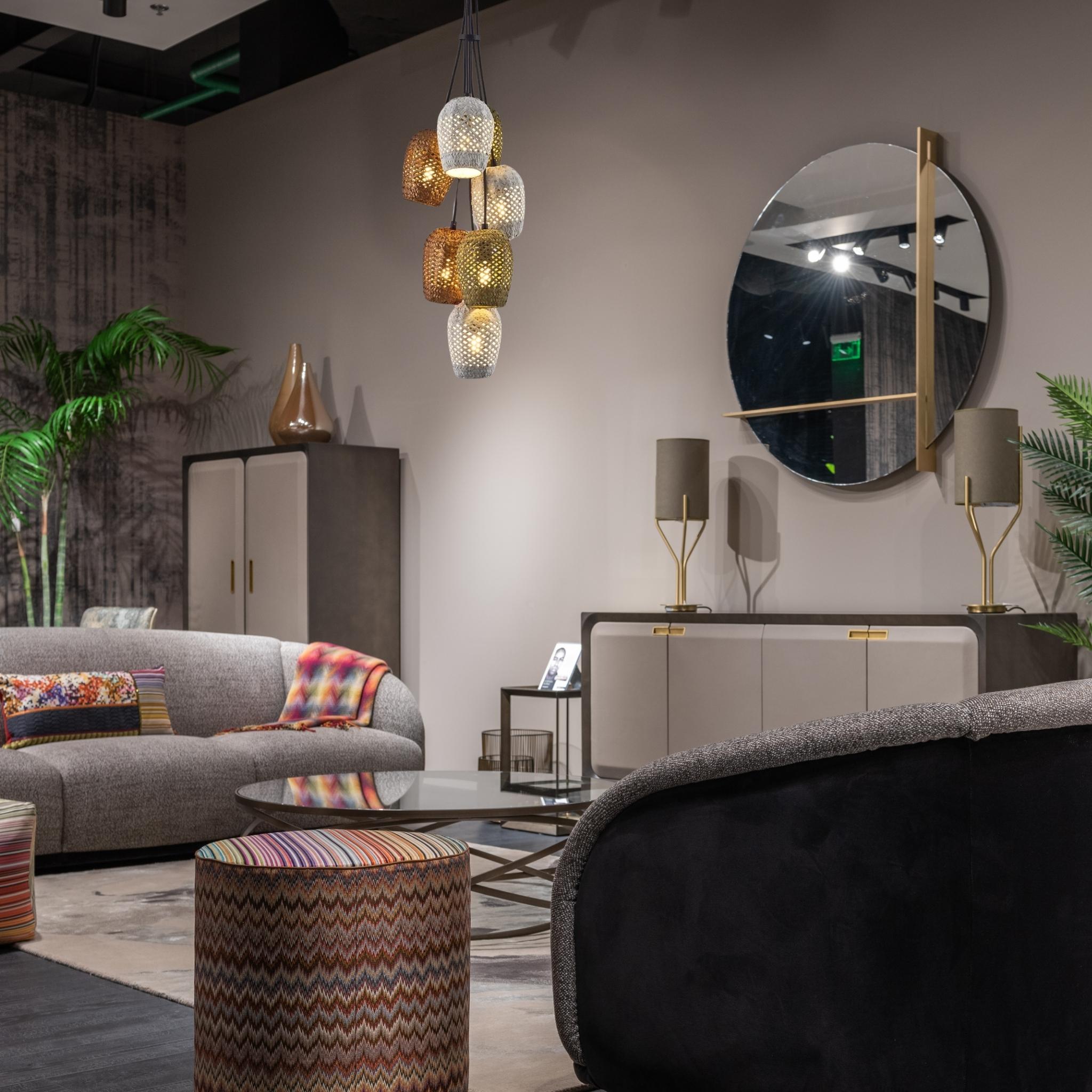 View of living room with sofa, pouf, sideboard, mirror, lighting.