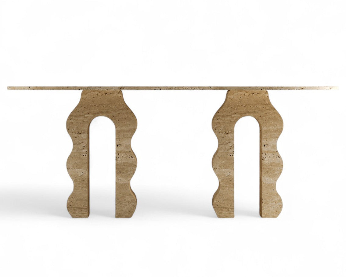 Travertine dining table with two wavy arch bases on white background
