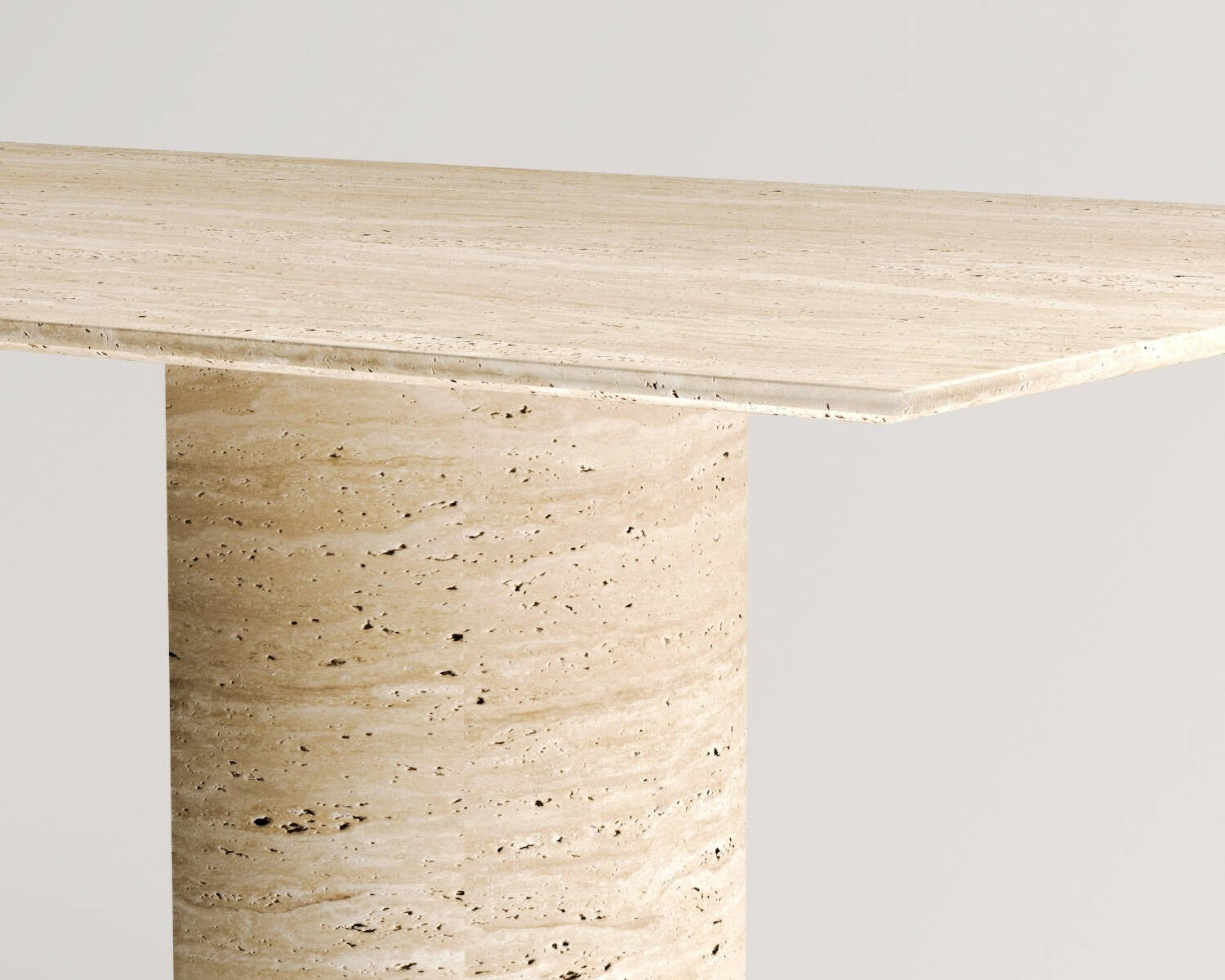 Close-up of Luzione travertine console table featuring a solid top and cylindrical base, highlighting the stone's texture and warm tones