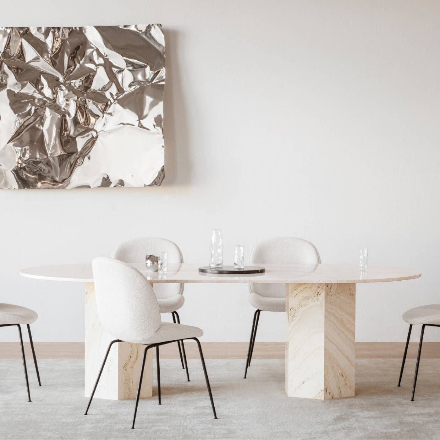 Interior dining room view with Luzione Aion travertine oval table, modern chairs, abstract art, and contemporary decor. Perfect for dining spaces