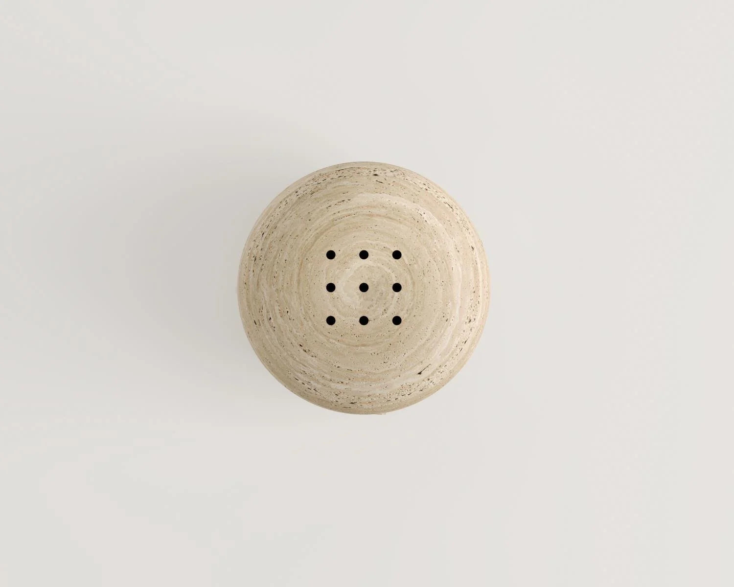 Overhead view of round beige stone decor with holes