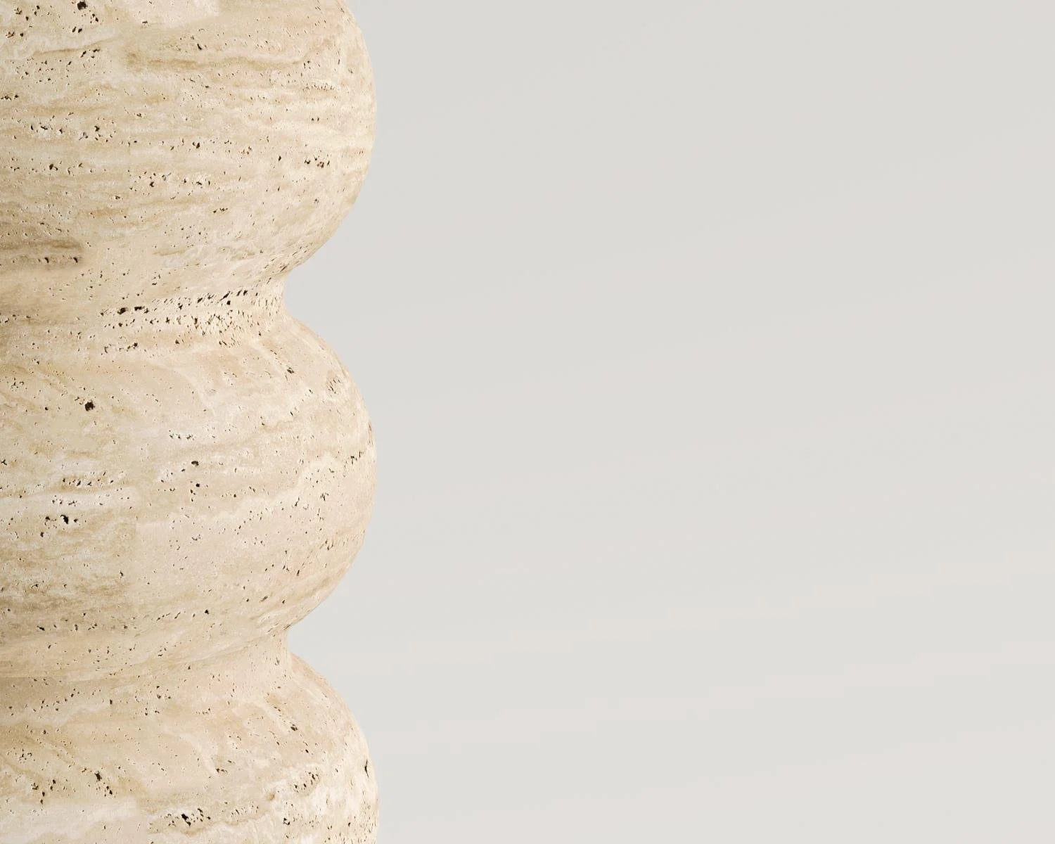 Close up view of travertine stone sculpture with undulating shape