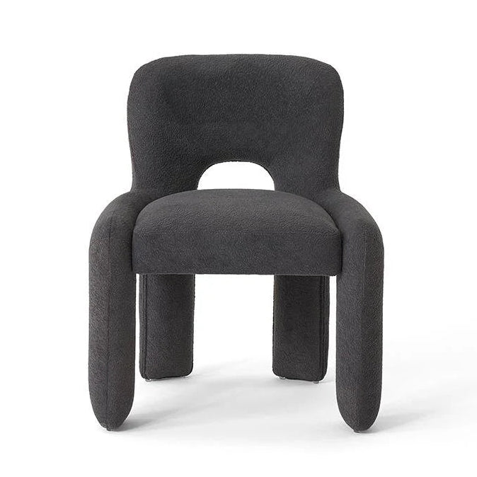 Studio shot of dark gray upholstered dining chair with cutout back.