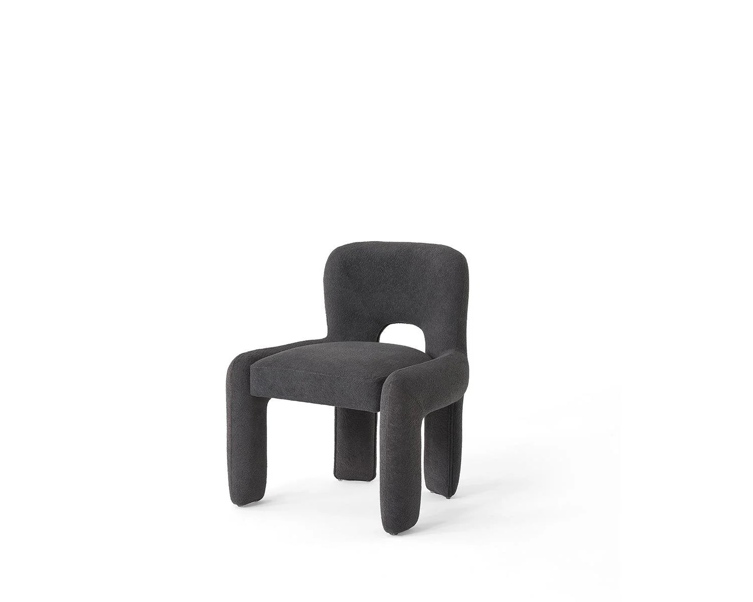 Dark gray upholstered chair with rounded legs and back cutout