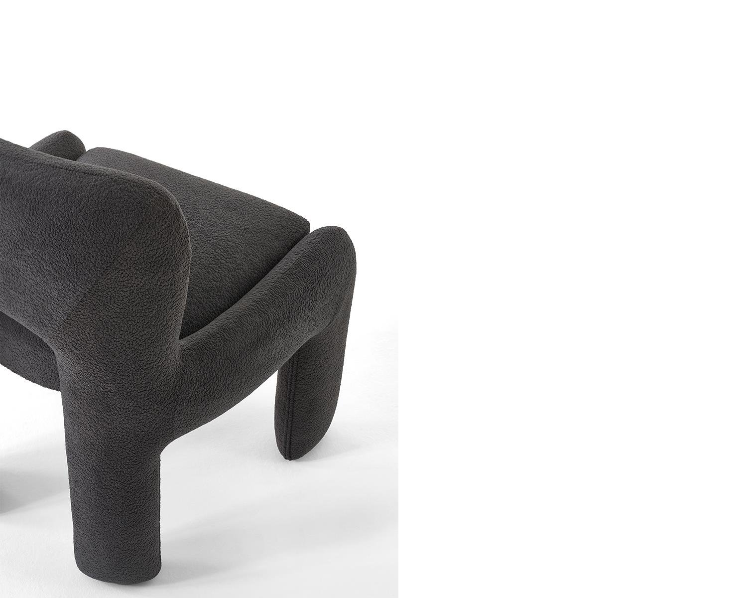 Close up view of dark gray upholstered armchair on white background