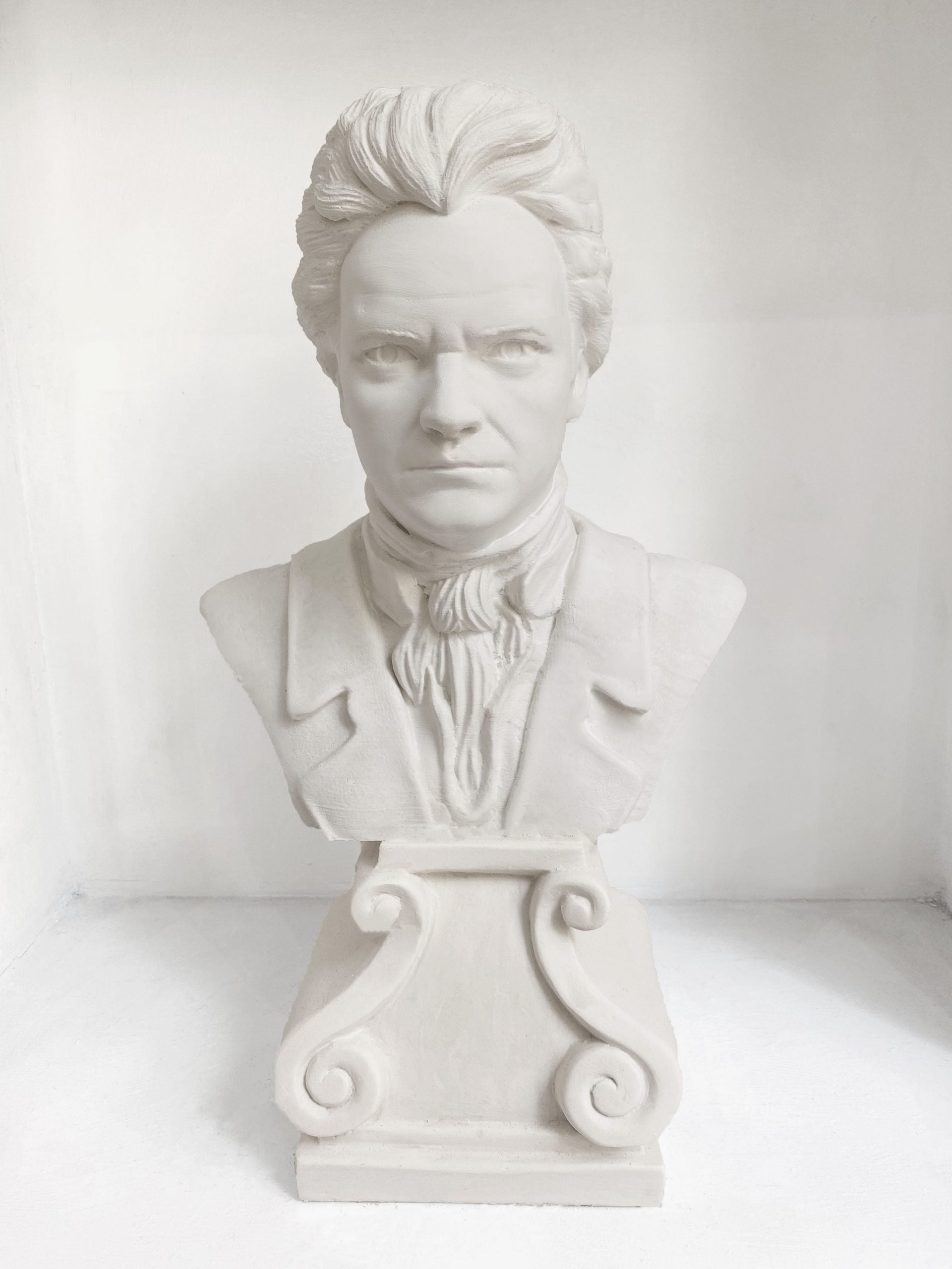 White plaster bust sculpture of a man in formal attire