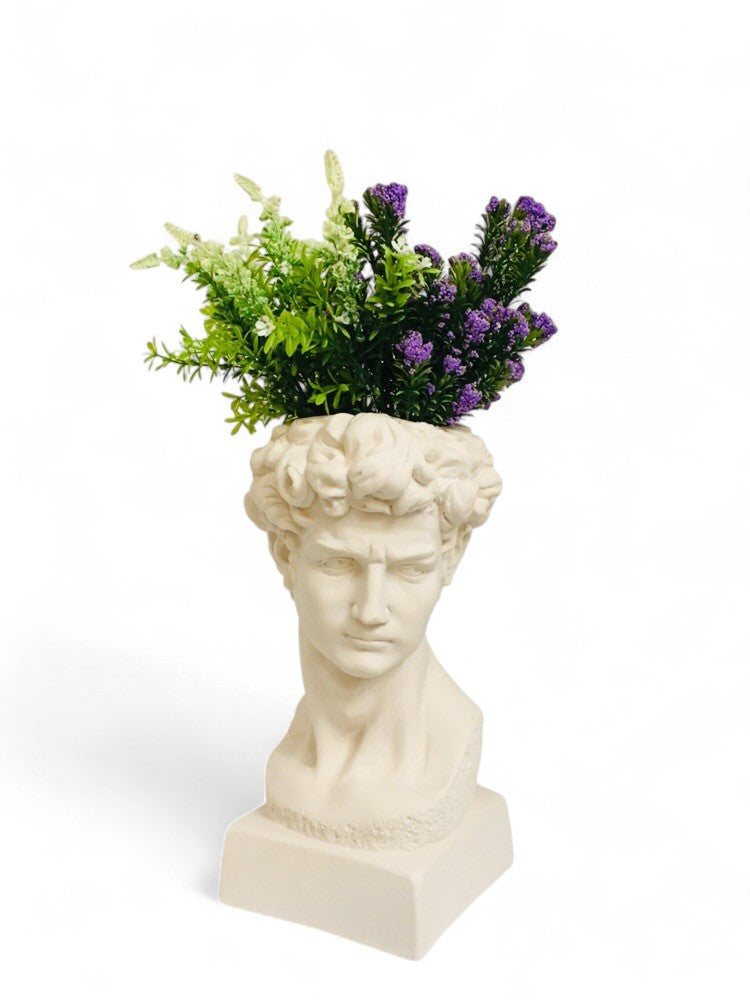 White bust sculpture planter with green and purple flowers decor