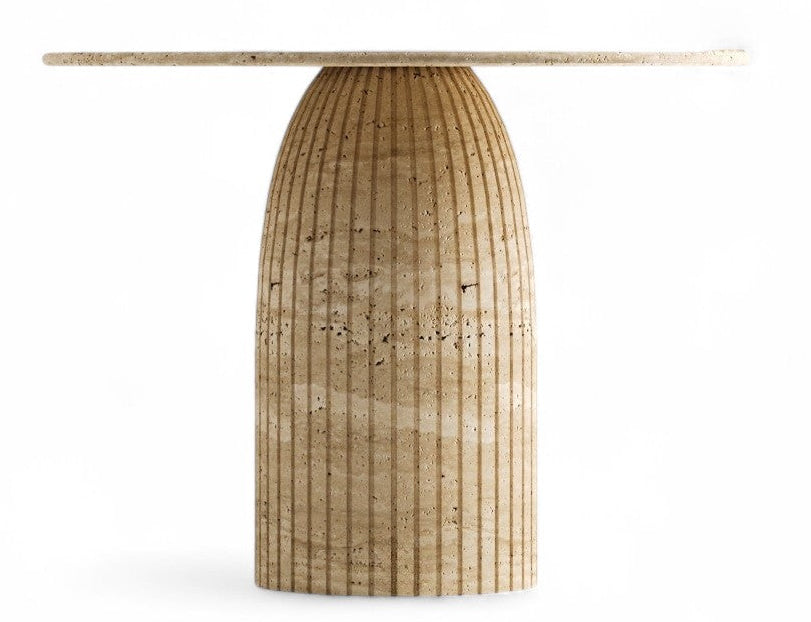 View of a fluted travertine pedestal table with round top on white background.