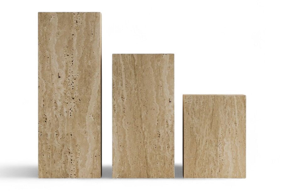 Three rectangular travertine pedestals in varying heights on white background