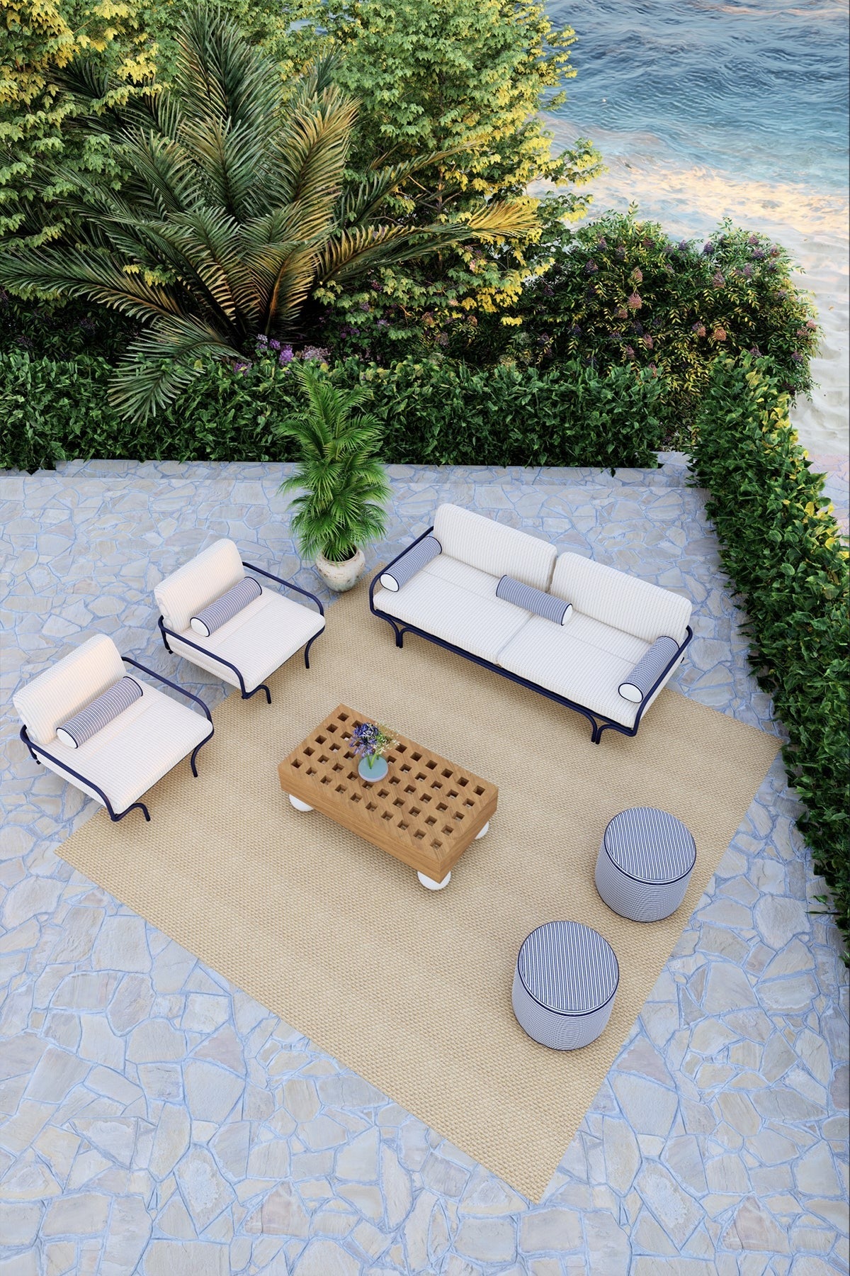 Outdoor patio set with white chairs, a coffee table, and ottomans on a stone patio.