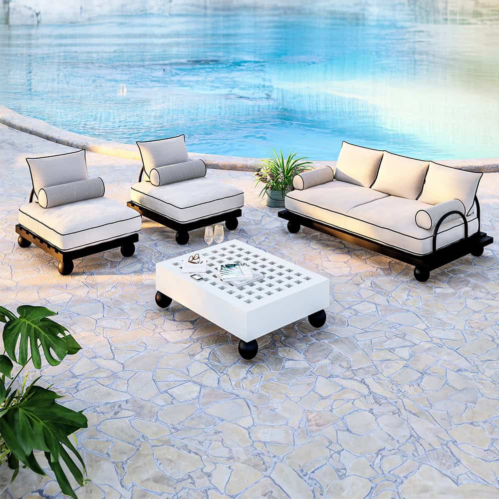 Outdoor furniture set with white cushions and black frames by pool.