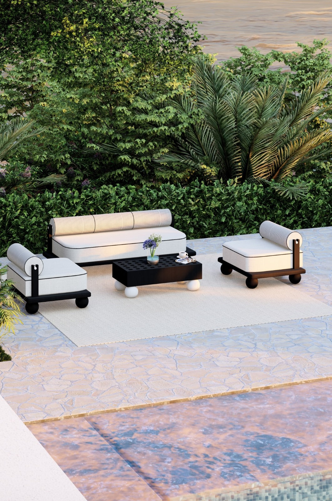 Outdoor patio set with white cushions and black wood on a stone patio surrounded by greenery