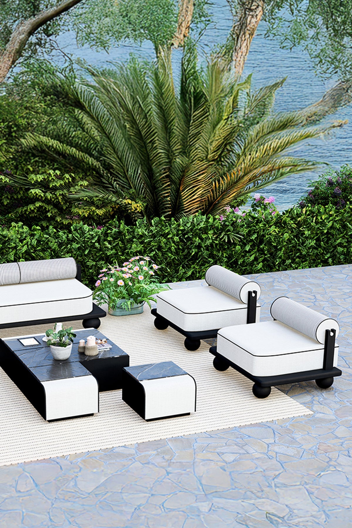 Outdoor patio furniture set with black and white chairs and table on a stone patio.