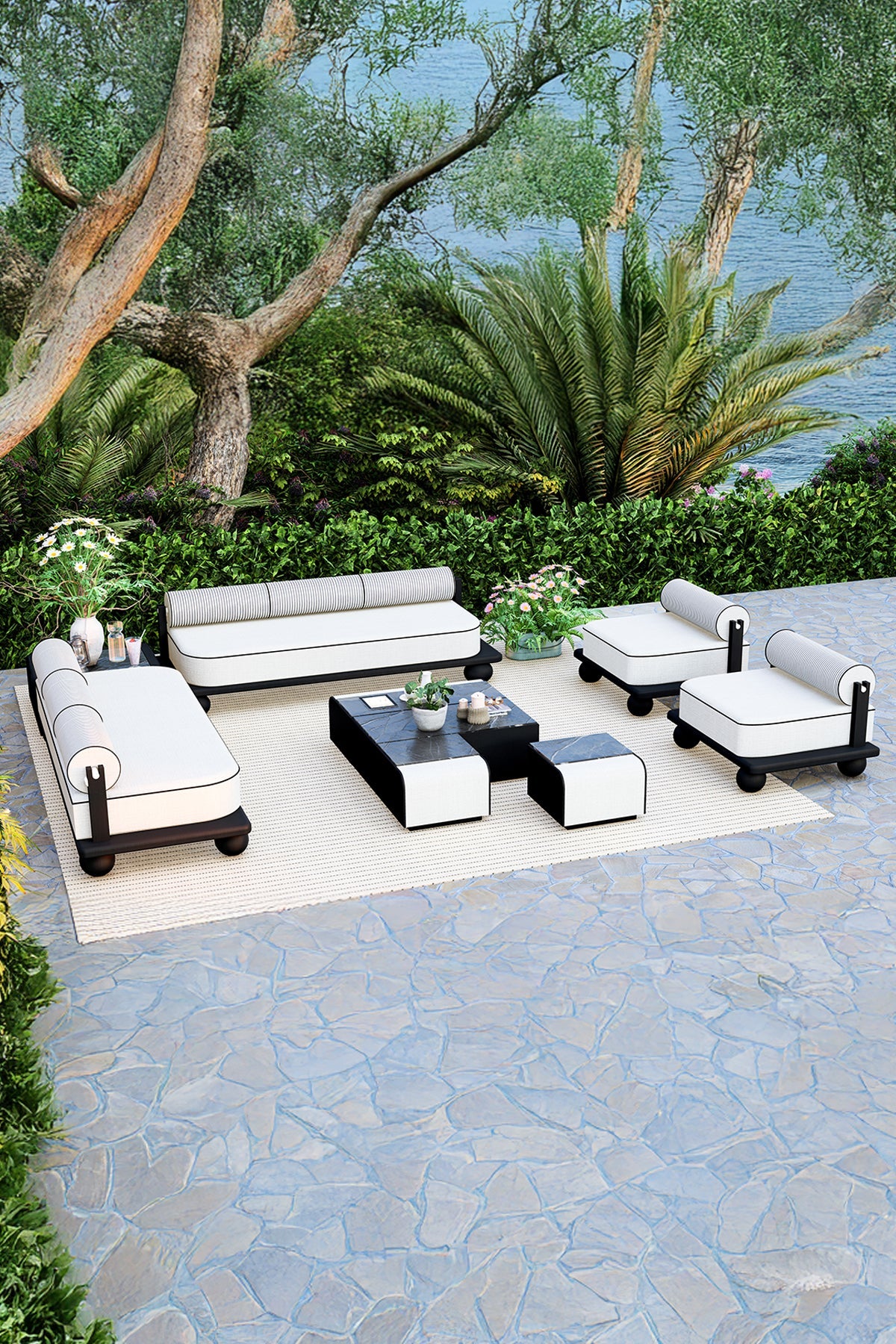 Outdoor patio set with white and black furniture on a stone patio.