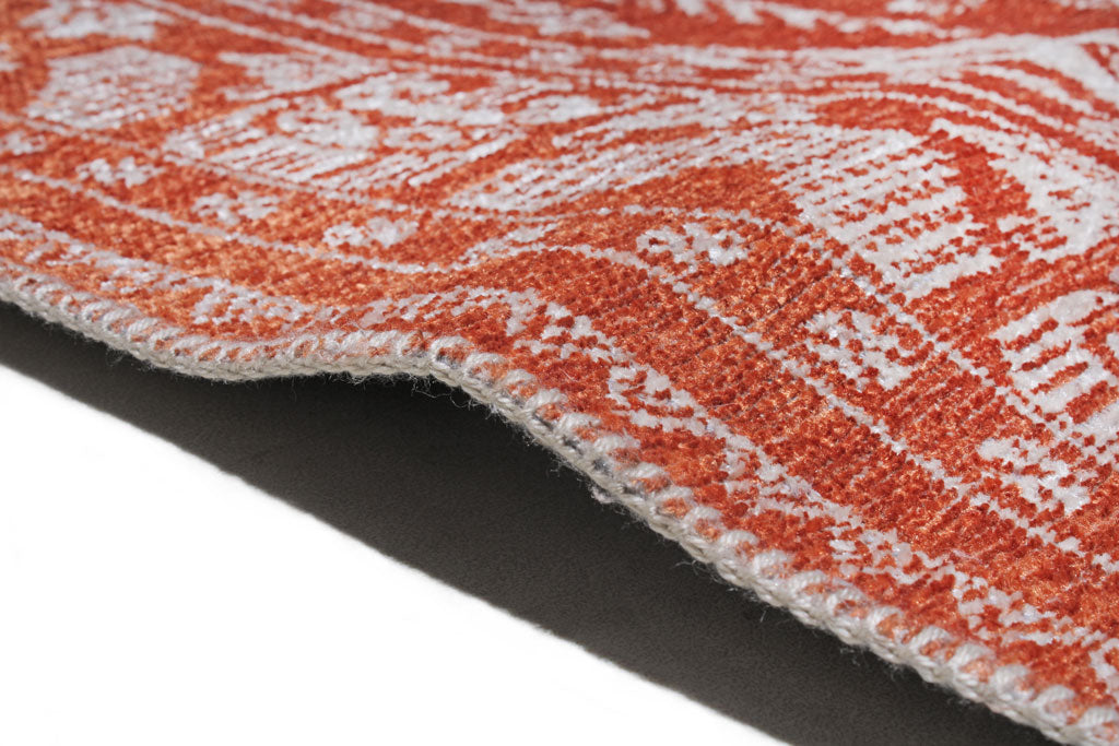 Close up view of orange and white patterned rug edge