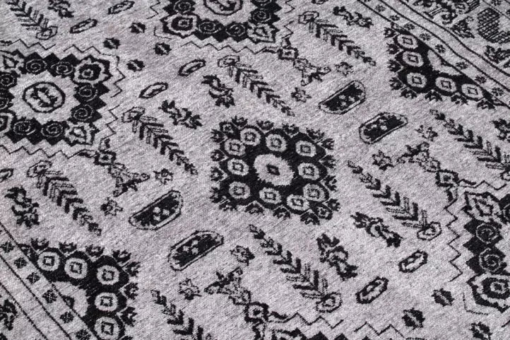 Close up view of gray rug with black geometric pattern