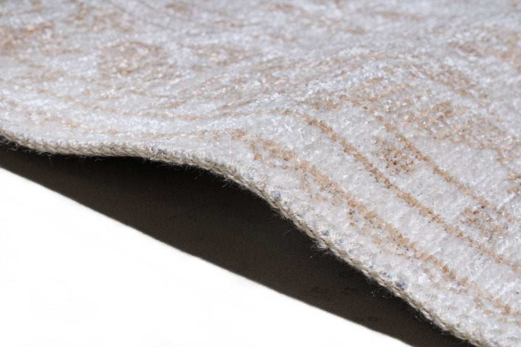 Close up view of beige and white patterned rug edge