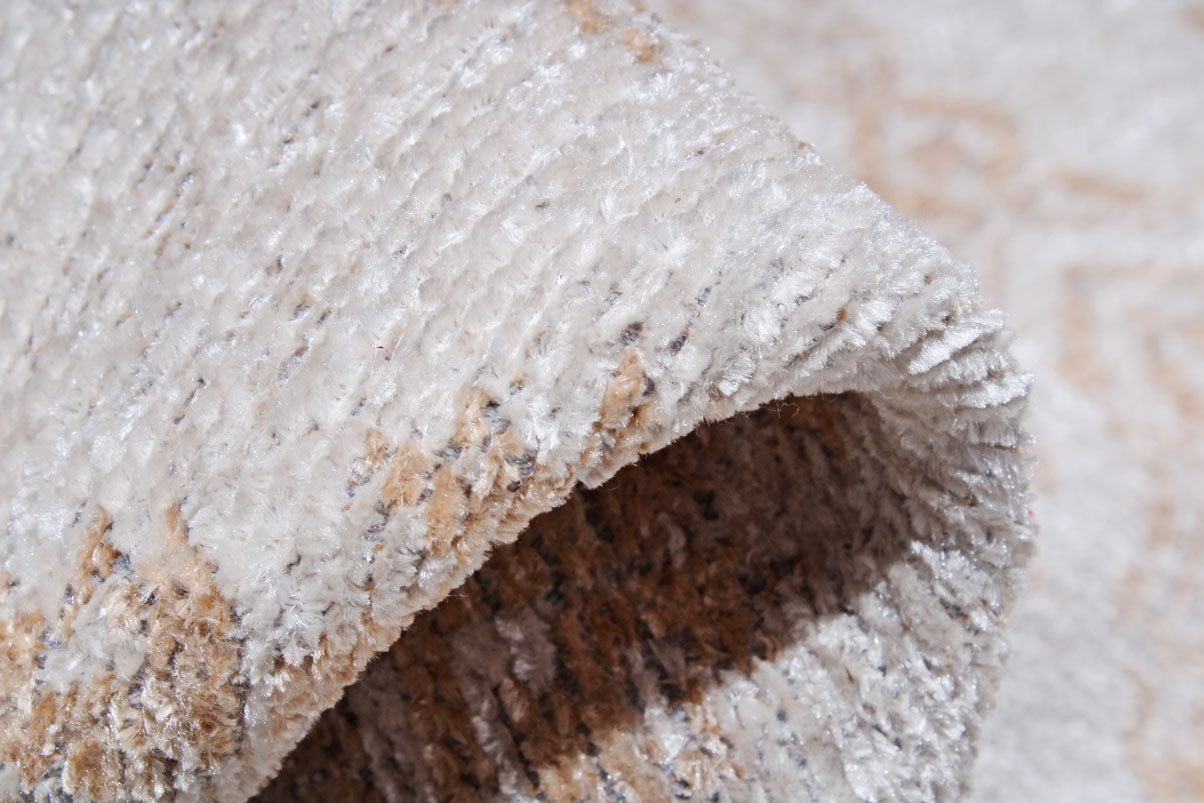 Close-up view of rolled beige and white area rug texture.