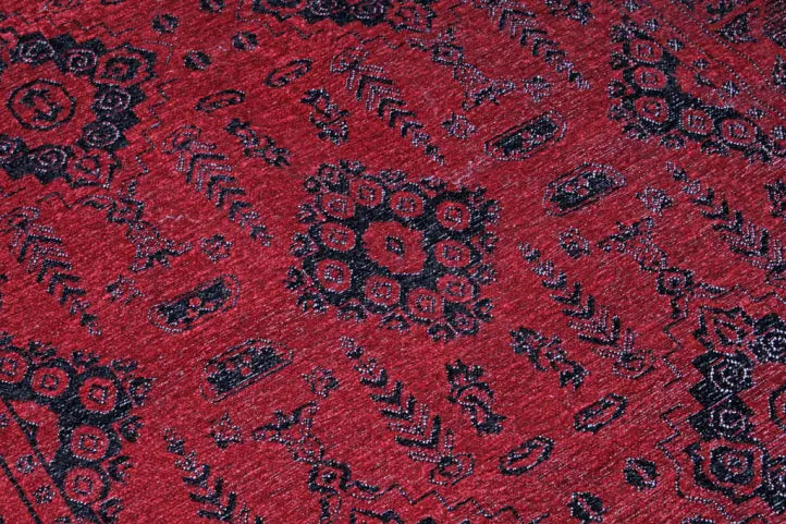 Red rug with black geometric pattern close up view