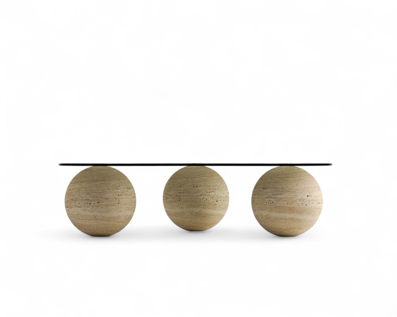 Three spherical travertine bases support a glass coffee table