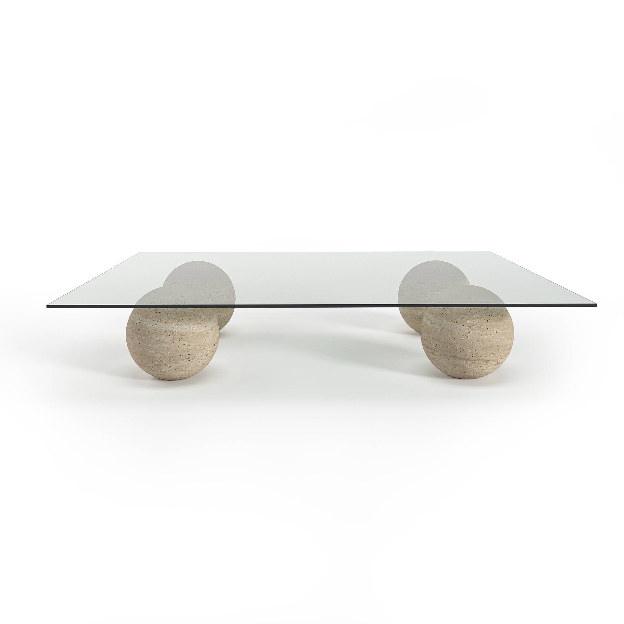 Luzione coffee table with a glass top and four spherical travertine stone bases. A modern, minimalist design for luxury living room decor