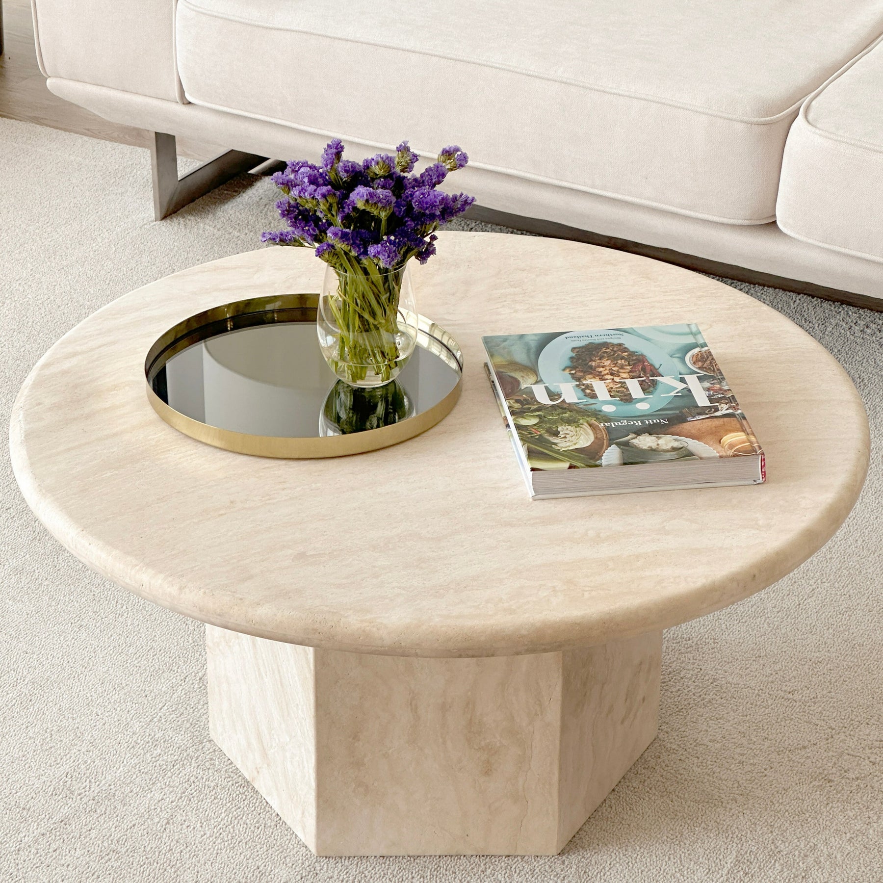 Close-up of Luzione's round travertine coffee table showcasing natural stone texture and modern design in a stylish living room