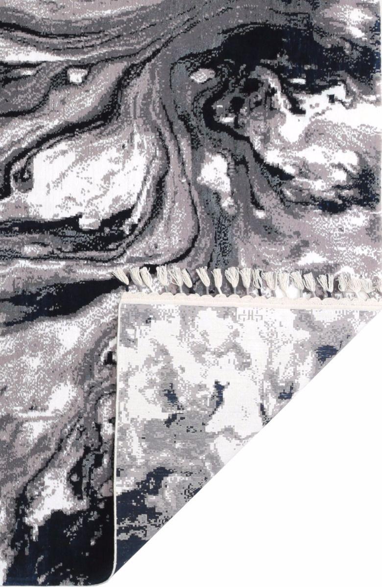 Gray black white abstract patterned rug with fringe showing underside