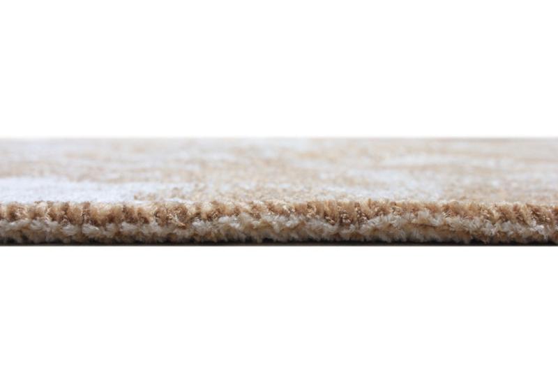 Close up view of beige and brown patterned rug edge
