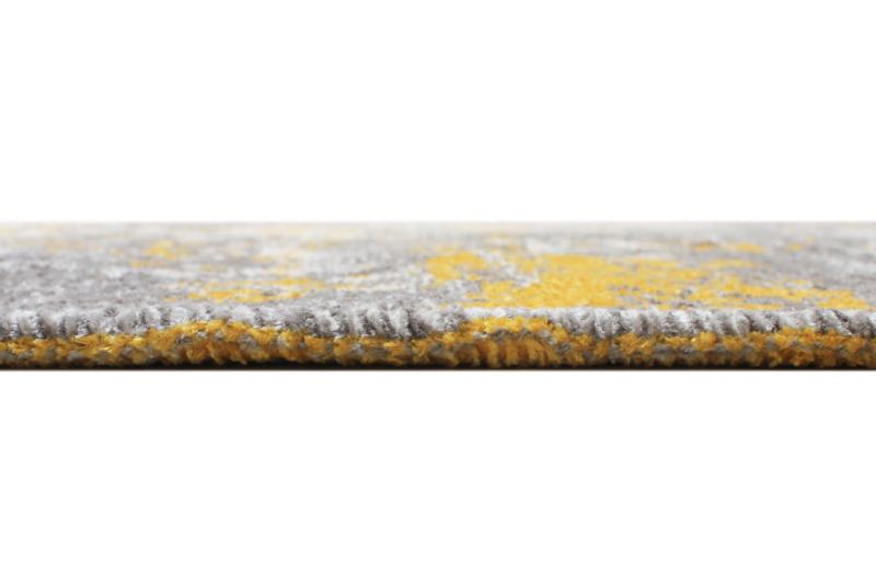 Close up of gray yellow abstract patterned rug edge